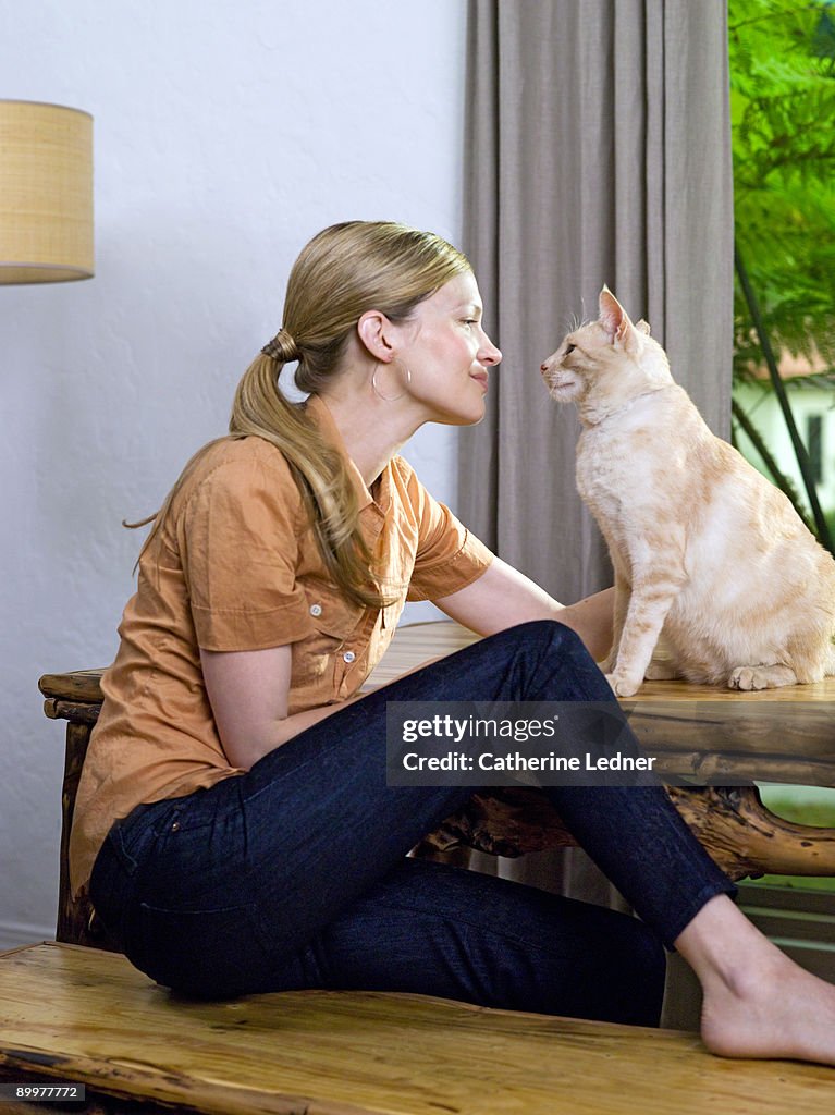 Woman looking at cat (Felis catus) lovingly