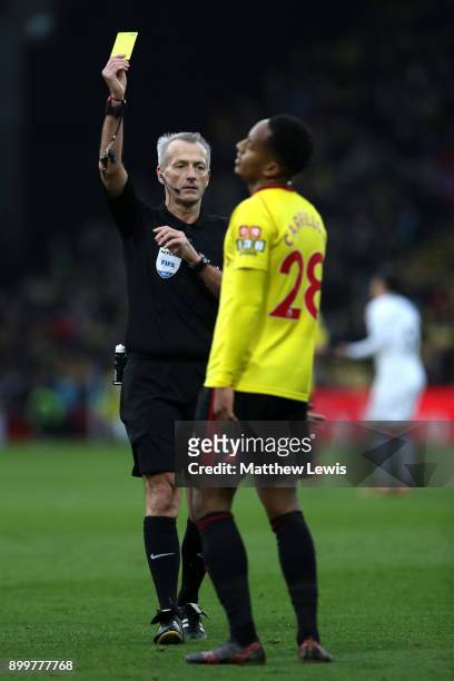 Andre Carrilo of Watford is shown a yellow card by referee Martin Atkinson during the Premier League match between Watford and Swansea City at...