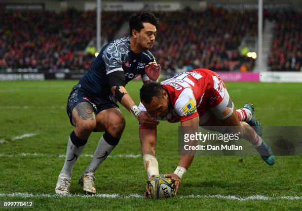 David Halaifonua of Gloucester dives over to score his side's first try past Denny Solomona of Sale Sharks during the Aviva Premiership match between...
