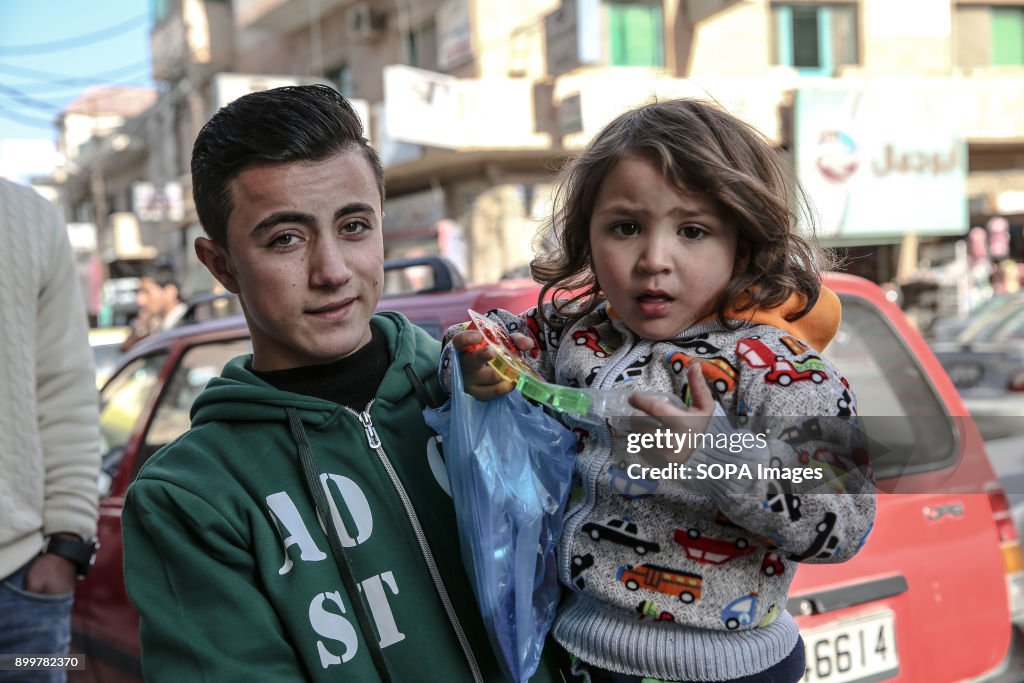 A young boy and girl stand outside a Syrian refugee centre...