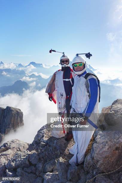 portrait of two wingsuit base jumpers preparing to fly - aviation risk stock-fotos und bilder