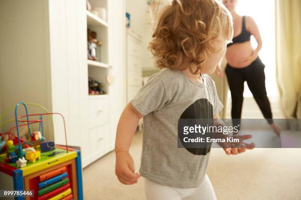 pregnant woman and daughter in bedroom - fuggire foto e immagini stock