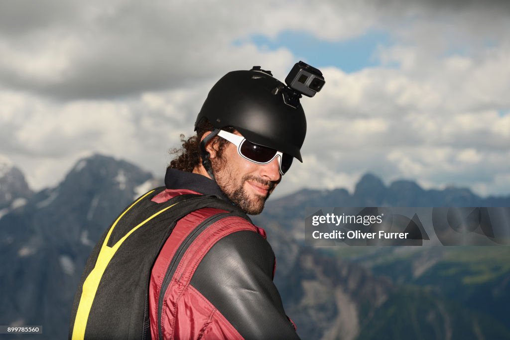 Portrait of base jumper wearing wingsuit with action camera on helmet, Dolomite mountains, Canazei, Trentino Alto Adige, Italy, Europe