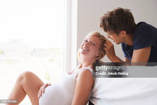 romantic pregnant couple in bedroom - jakob helbig stock pictures, royalty-free photos & images