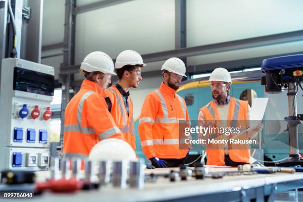 group of apprentices with instructor at railway engineering facility - training hard hat stock pictures, royalty-free photos & images