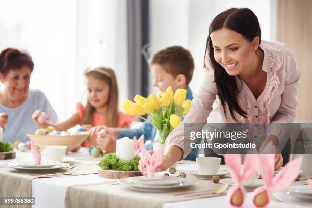 woman and family preparing place settings at easter dining table - daily life in poland ストックフォトと画像