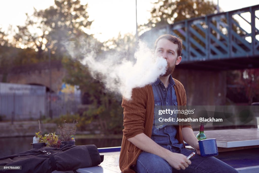 Man smoking e-cigarette on canal boat