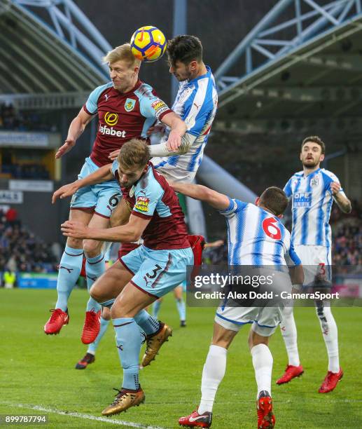 Burnley's Ben Mee battles with Huddersfield Town's Christopher Schindler during the Premier League match between Huddersfield Town and Burnley at...