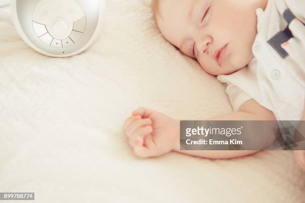 baby boy sleeping, baby monitor on bed beside him - babyphone stock-fotos und bilder