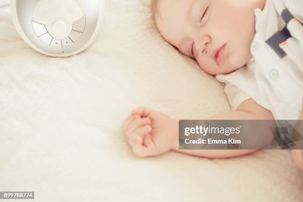 baby boy sleeping, baby monitor on bed beside him - baby monitor stock pictures, royalty-free photos & images