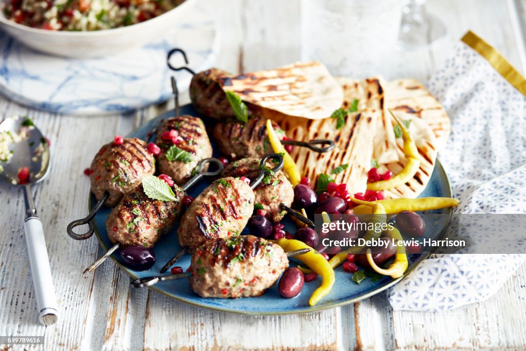 Lamb kofta and flat bread on plate, close-up