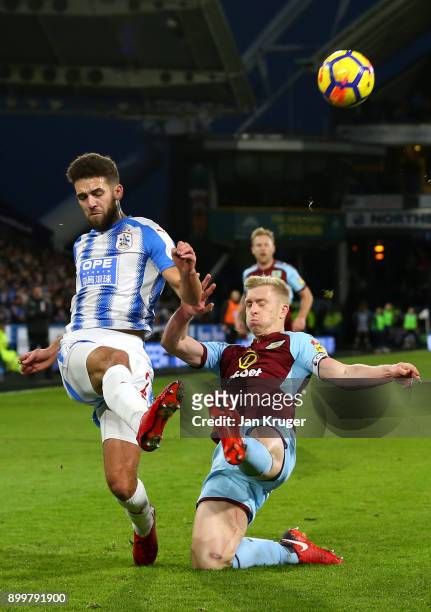 Tommy Smith of Huddersfield Town is challenged by Ben Mee of Burnley during the Premier League match between Huddersfield Town and Burnley at John...