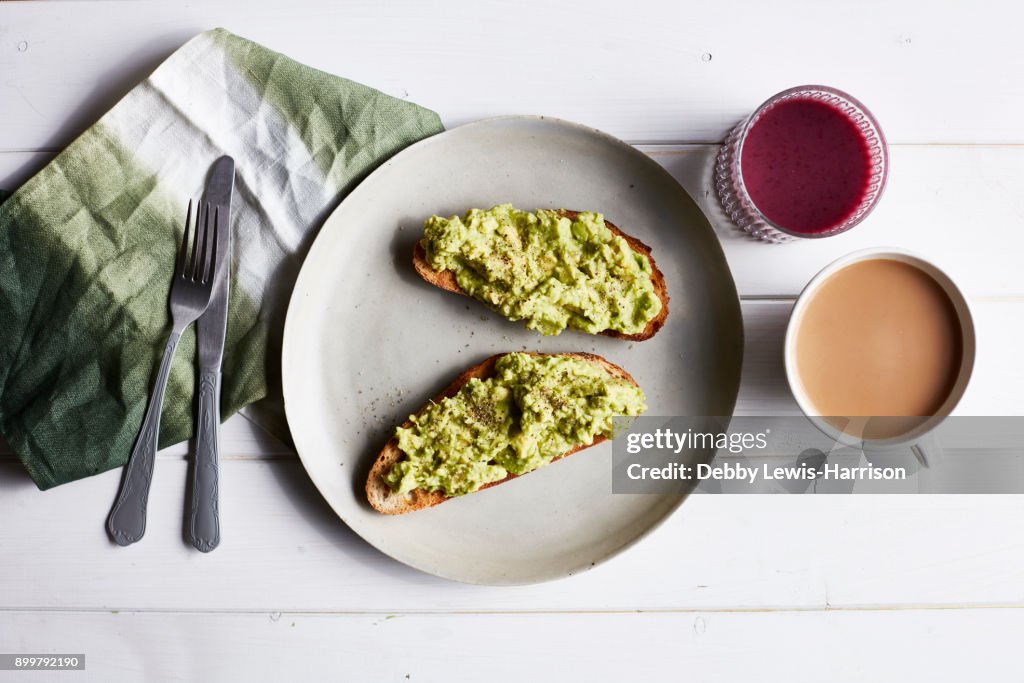 Avocado on toast on white plate, overhead view