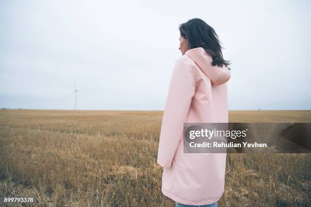 woman in raincoat on field, odessa, ukraine - estar-en-las-nubes fotografías e imágenes de stock