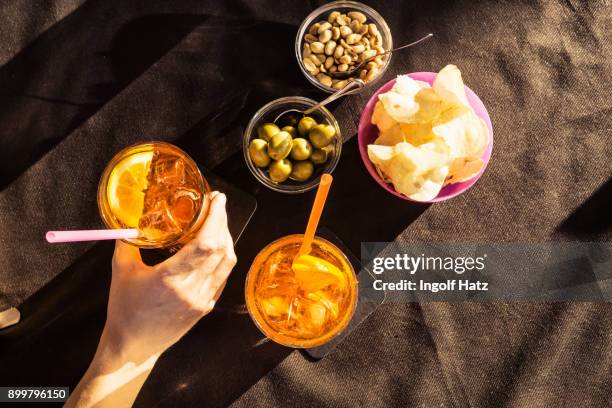 overhead view of sidewalk cafe table with womans hand holding aperitif, riccione, emilia-romagna, italy - 食前酒 ストックフォトと画像