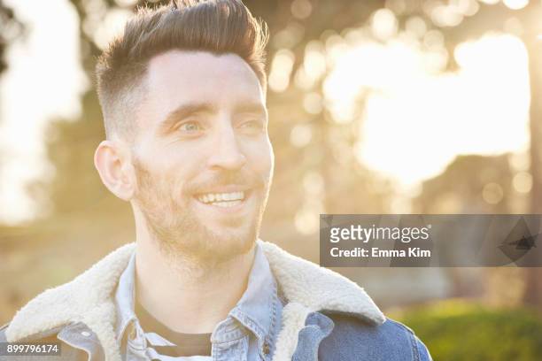 hazy lens flare portrait of bearded young man - portrait lens flare stock pictures, royalty-free photos & images