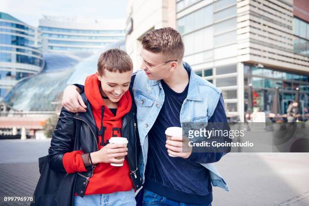romantic young couple with takeaway coffee walking together in city - disposable cup foto e immagini stock