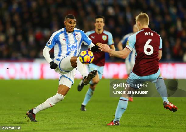 Collin Quaner of Huddersfield Town is challenged by Ben Mee of Burnley during the Premier League match between Huddersfield Town and Burnley at John...