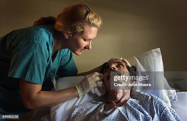 Registered Nurse N. Von Reiter comforts Ramond Garcia as his health quickly declines at the Hospice of Saint John on August 20, 2009 in Lakewood,...