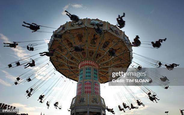 Children are whipped around on swings on one of the many carnival rides at the 61st Montgomery County Agricultural Fair on August 19, 2009 in...