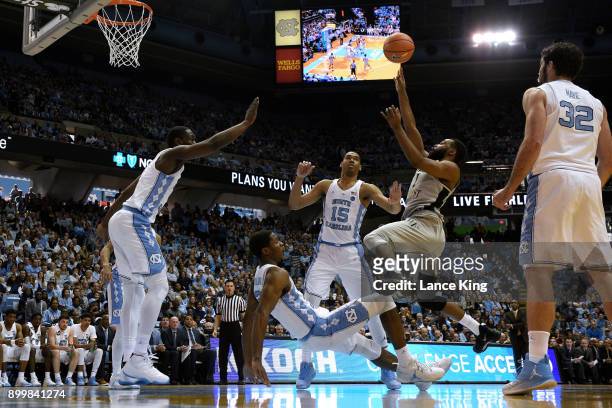 Keyshawn Woods of the Wake Forest Demon Deacons puts up a shot against Kenny Williams of the North Carolina Tar Heels at Dean Smith Center on...