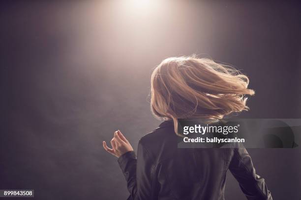 woman dancing in a nightclub - blonde hair black background stock pictures, royalty-free photos & images