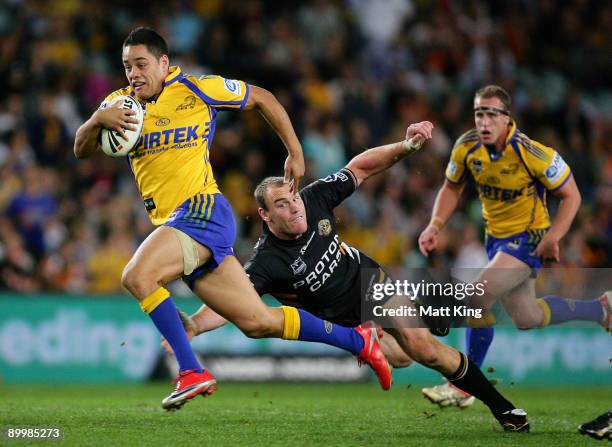 Jarryd Hayne of the Eels makes a break past the tackle of Gareth Ellis of the Tigers during the round 24 NRL match between the Wests Tigers and the...