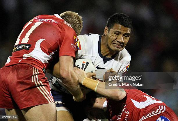 Lagi Setu of the Broncos is tackled during the round 24 NRL match between the St George Illawarra Dragons and the Brisbane Broncos at WIN Stadium on...