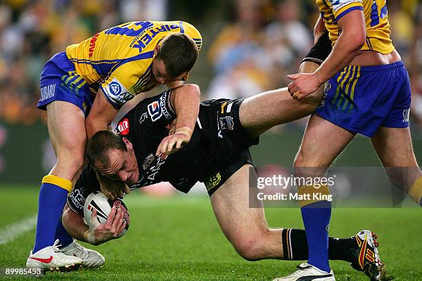 Gareth Ellis of the Tigers is tackled during the round 24 NRL match between the Wests Tigers and the Parramatta Eels at the Sydney Football Stadium...