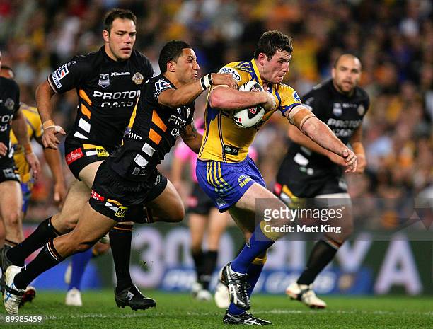 Ben Smith of the Eels is tackled from behind by Benji Marshall of the Tigers during the round 24 NRL match between the Wests Tigers and the...