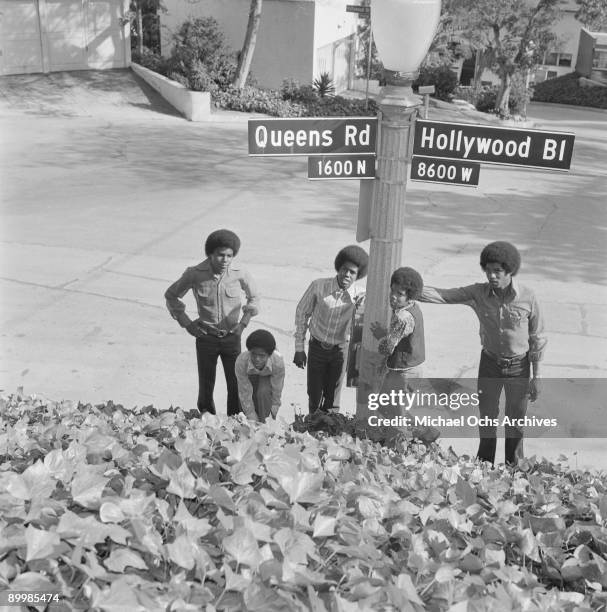 American singer Michael Jackson and the Jackson Five pose by the sign for Queens Road and Hollywood Boulevard in Los Angeles, circa 1971. From left...