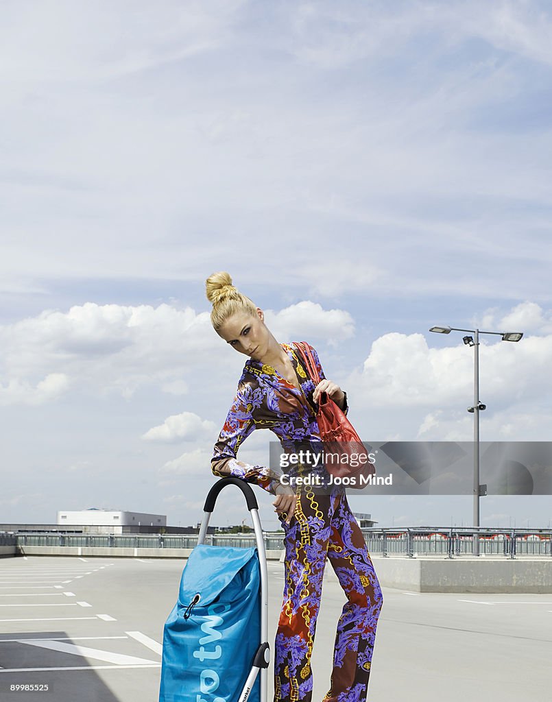 Woman with shopping trolley on rooftop car park