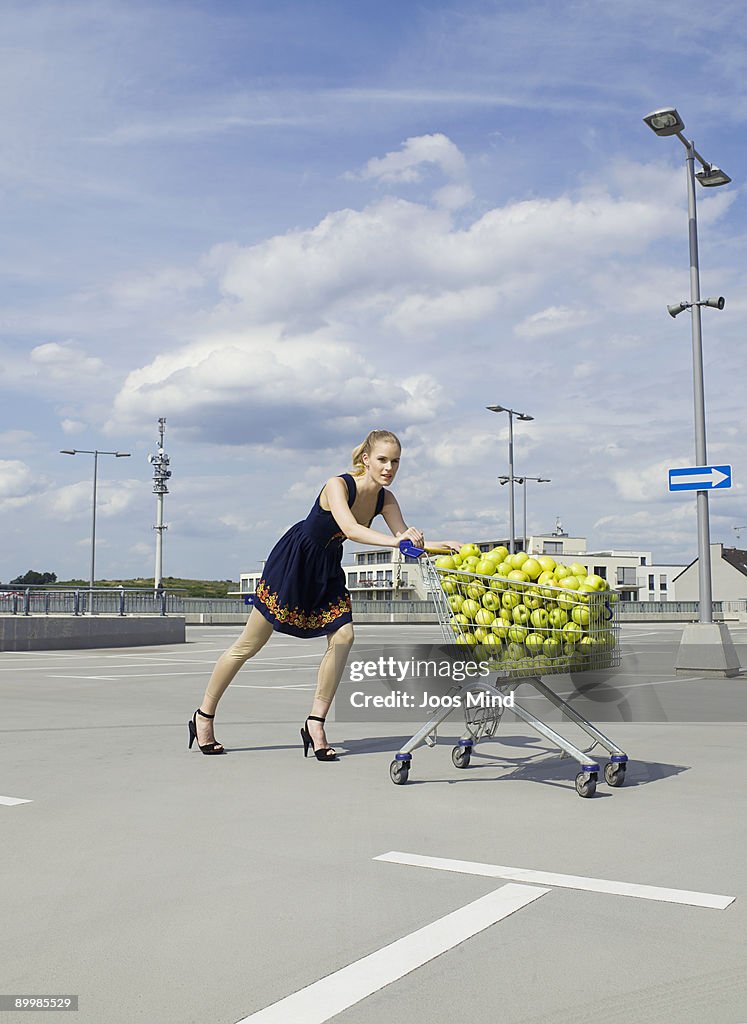 Young woman pushing shopping cart
