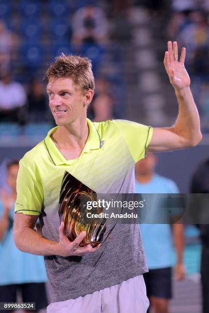 Kevin Anderson of South Africa celebrates with the trophy after his final match against Roberto Bautista Agut of Spain on day three of the Mubadala...