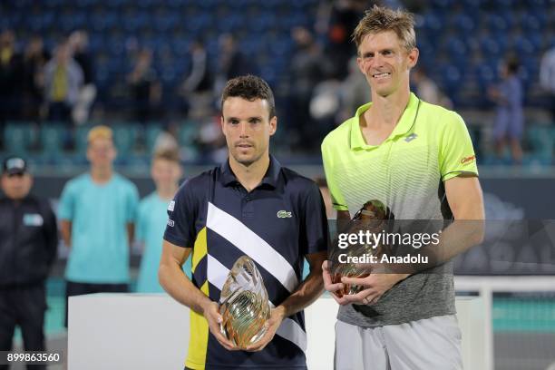 Champion of 2017 Mubadala World Tennis Championship Kevin Anderson of South Africa poses with Roberto Bautista Agut of Spain after their final match...