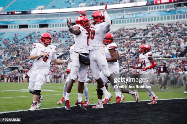 Lamar Jackson of the Louisville Cardinals celebrates with teammate Charles Standberry after running for a touchdown in the first half of the...