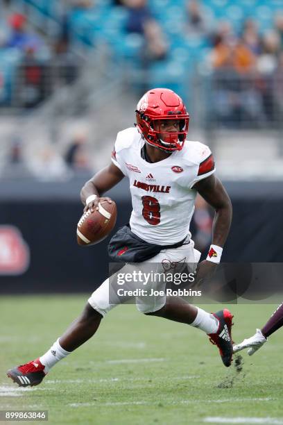 Lamar Jackson of the Louisville Cardinals runs the ball in the first half of the TaxSlayer Bowl against the Mississippi State Bulldogs at EverBank...