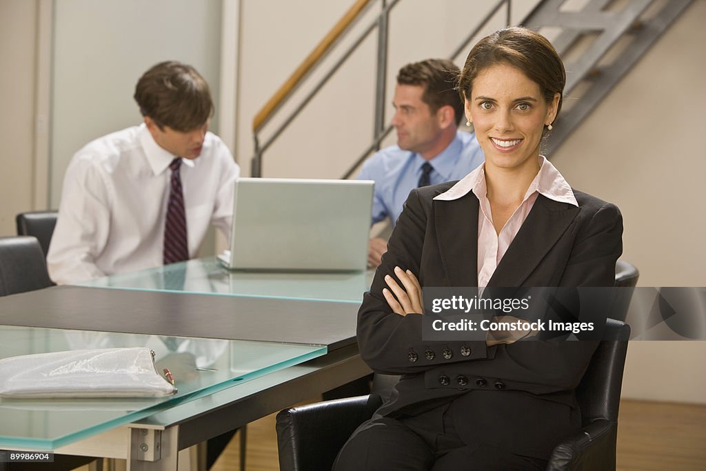 Business woman with co-workers in background
