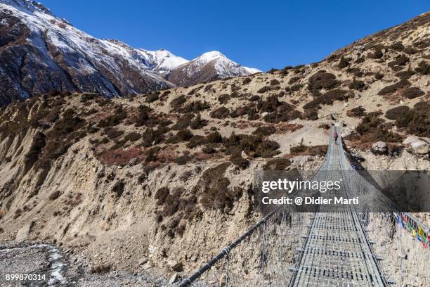 suspension bridge along the annapurna circuit trek in nepal - annapurna circuit photos et images de collection