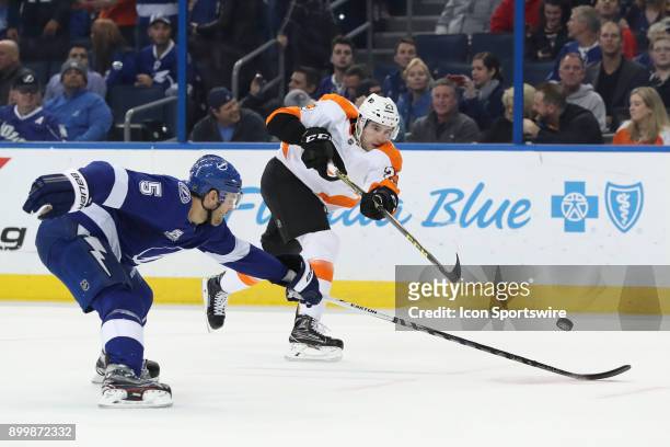 Philadelphia Flyers defenseman Brandon Manning takes a shot past the stick of Tampa Bay Lightning defenseman Dan Girardi in the first period of the...