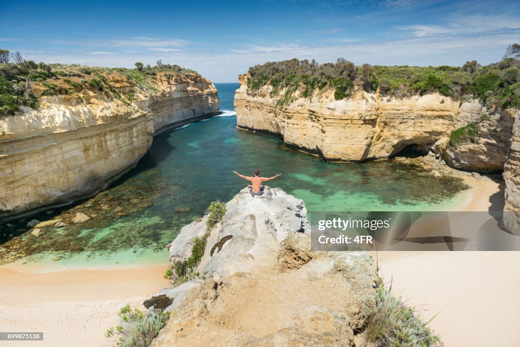 Tourist overlooking the beautiful Loch Ard Gorge, Great Ocean Road, Australia