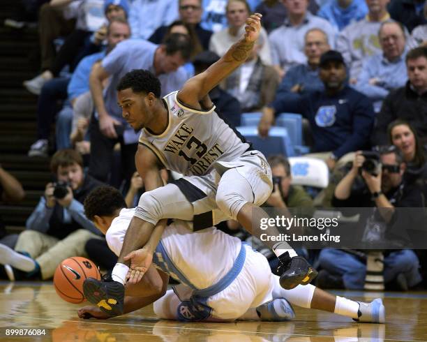 Bryant Crawford of the Wake Forest Demon Deacons collides with Cameron Johnson of the North Carolina Tar Heels while chasing a loose ball at Dean...