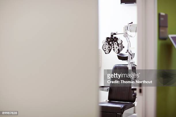 view from hallway into a vision exam room - phoropter stockfoto's en -beelden
