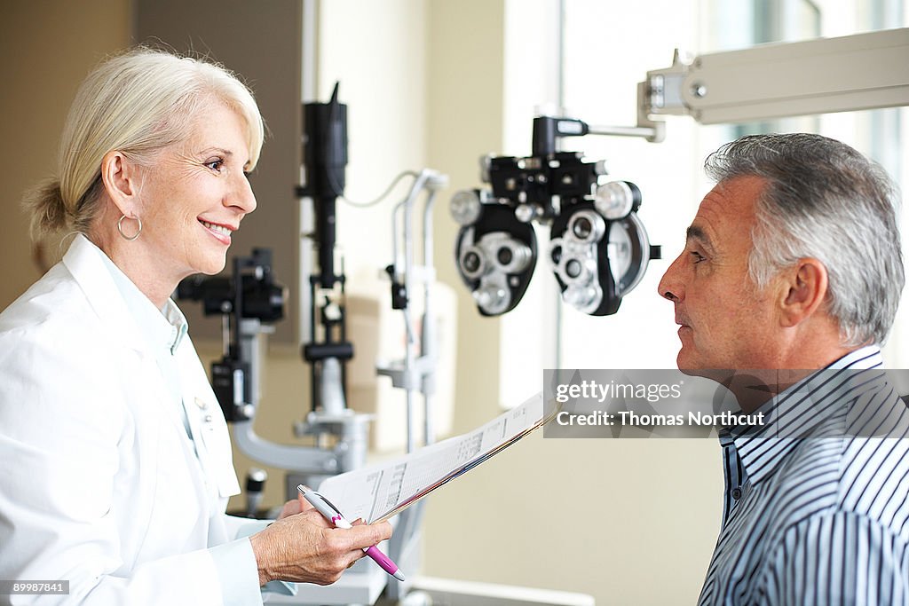 A female opthamologist listens to her patient.