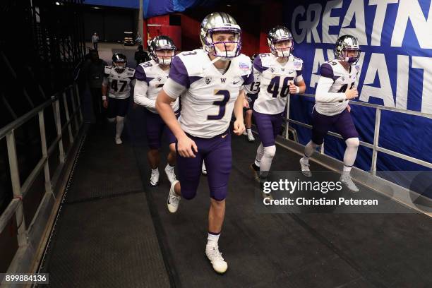 Quarterback Jake Browning of the Washington Huskies leads teammates onto the field before the Playstation Fiesta Bowl against the Penn State Nittany...