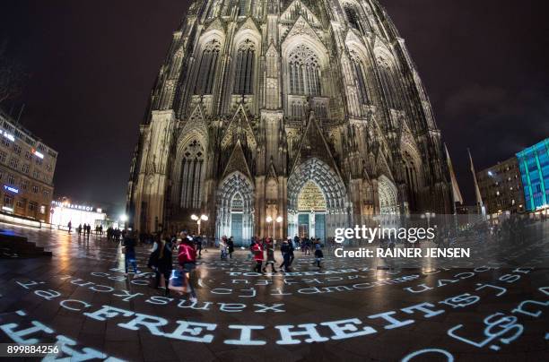 "Freedom" and other words are being displayed on the ground in front of the Cologne Cathedral on December 30, 2017 in Cologne, western Germany, as...