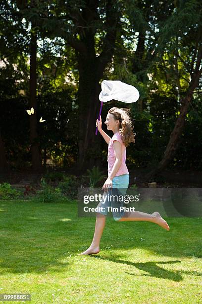young girl chasing butterflies. - chasing butterflies stock pictures, royalty-free photos & images