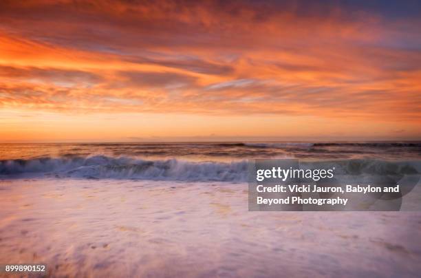 foam and orange sky at jones beach - fire eiland kustgebied stockfoto's en -beelden