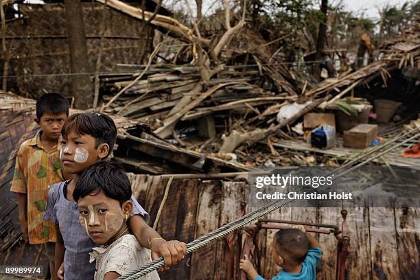Two young girls sit on a fallen tree in the village of Kan Sake May 10, 2008 a few hours south of Pyapon, Myanmar. On May 2, 2008 Myanmar was hit by...