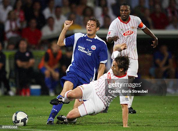 Marcel Schied of Rostock battles for the ball with Daniel Goehlert and Younga Mouhani of Berlin during the Second Bundesliga match between 1. FC...